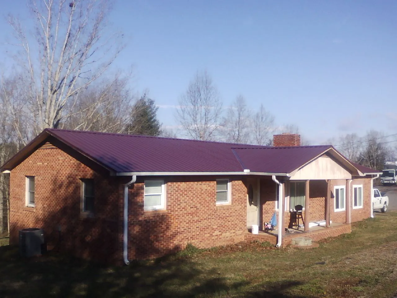 Burgundy metal roof on a brick ranch home with a new addition in Moncks Corner