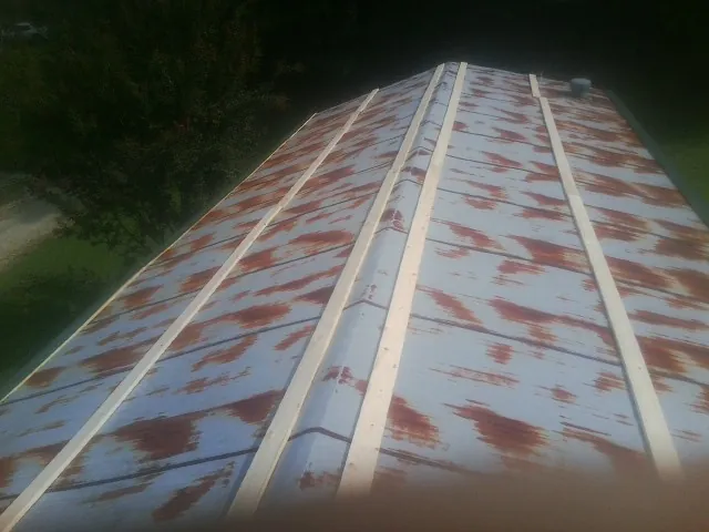 Rusted metal roof panels with new wood purlins before replacement — Storm Damage Roof Repair in Moncks Corner by Roofing Brothers