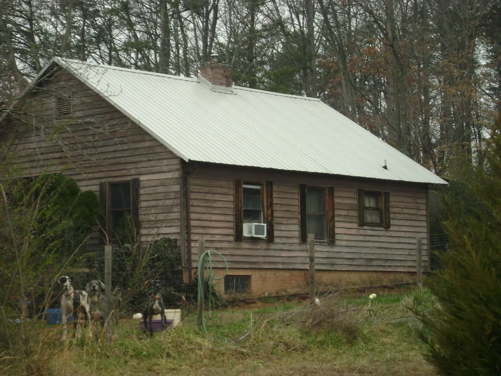 White metal roof on an old wood sided farmhouse, from a Metal Roof Installation job in Moncks Corner